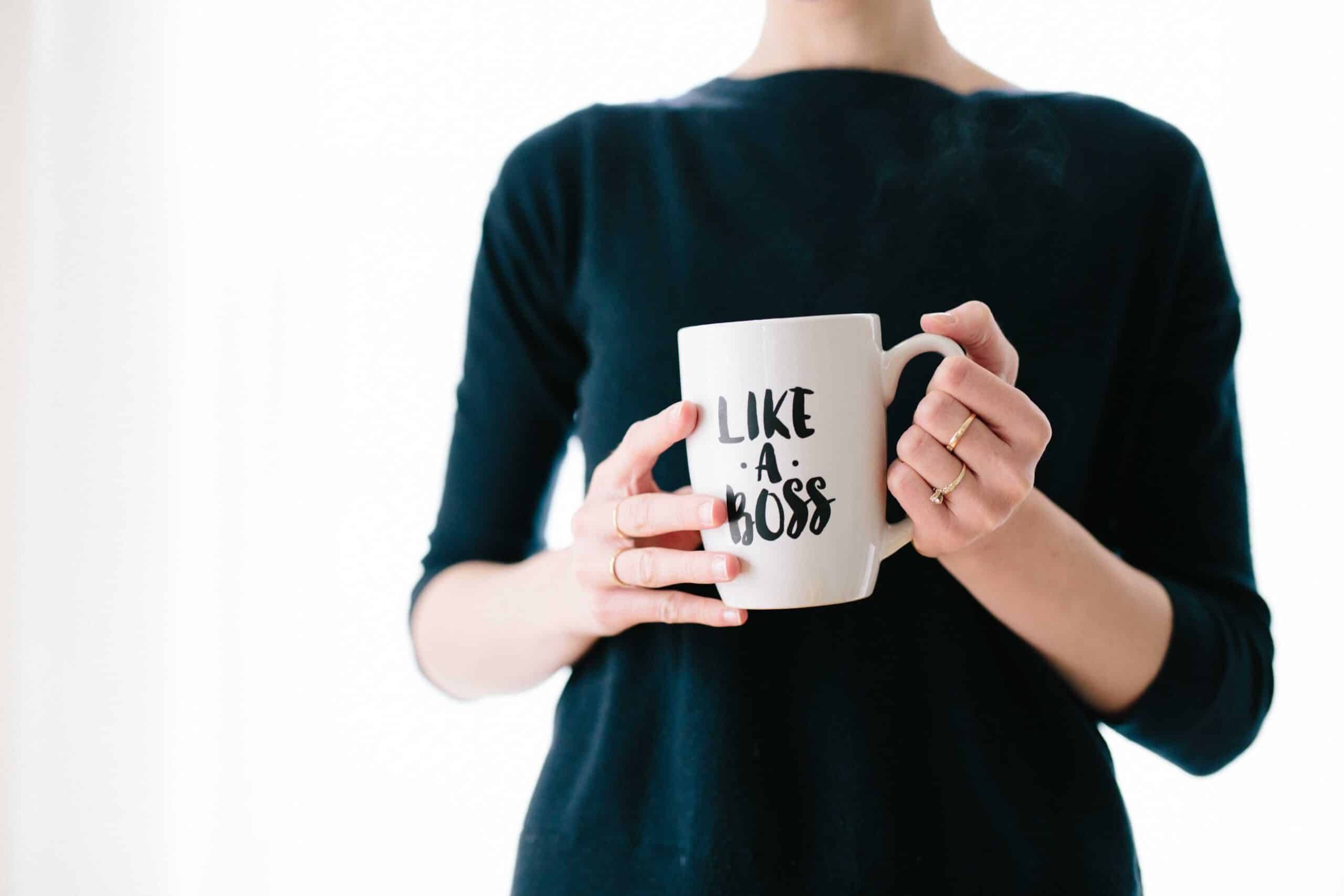 Picture of a woman holding a cup that says "like a boss". Illustrates the power of building your personal brand.