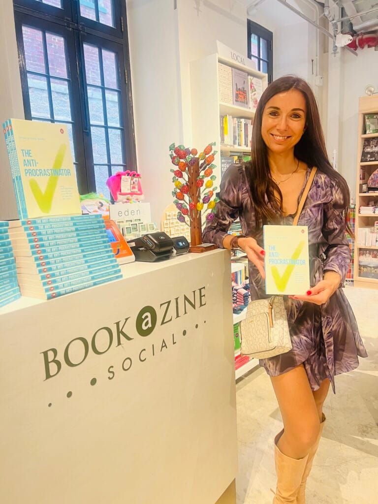 Woman holding a book of The Anti-Procrastinator